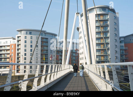 Zwei Menschen, die zu Fuß über den Fluss Aire auf Ritter Brücke, Clarence Dock, Leeds, West Yorkshire, England, UK