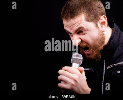 Schrei der männlichen böse Rocker am Mikrofon mit Exemplar Stockfoto