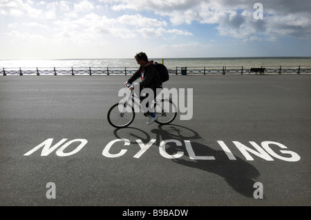 Ein Radfahrer ignorieren ein "No Radfahren Schild am Strand von Brighton und Hove. Stockfoto