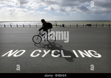 Ein Radfahrer ignorieren ein "No Radfahren Schild am Strand von Brighton und Hove. Stockfoto