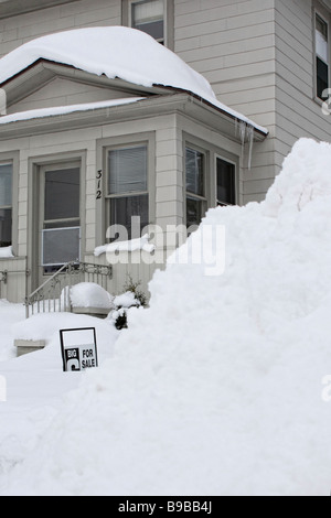 Winter Munising Upper Peninsula Michigan MI in den USA USA eine kleine Stadt unter dem schneebedeckten Haus auf der Stadtstraße Bilder im vertikalen Hochformat Stockfoto