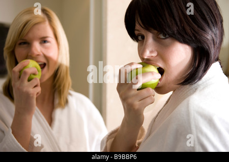 Zwei Frauen Essen / in Einen Apfel Beissen Stockfoto