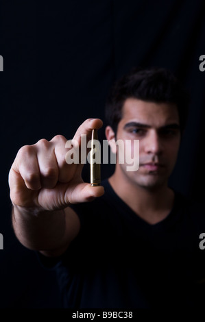 Junger Mann hält eine Kugel Stockfoto