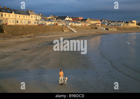 Mann mit Hund geht am Strand in Kilkee, Westküste Irlands, County Clare Stockfoto