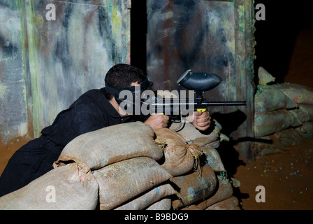 Junger Mann Paintball spielen Stockfoto