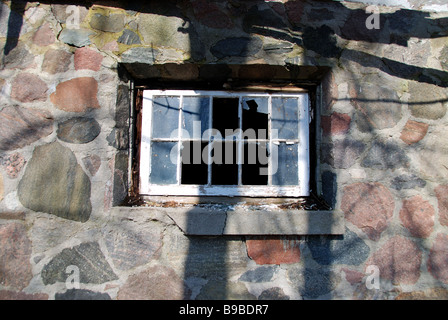 Kaputte Fenster an der Seite eines historischen Steinhauses auf dem Gelände des Gildengasthauses, das seitdem abgerissen wurde Stockfoto