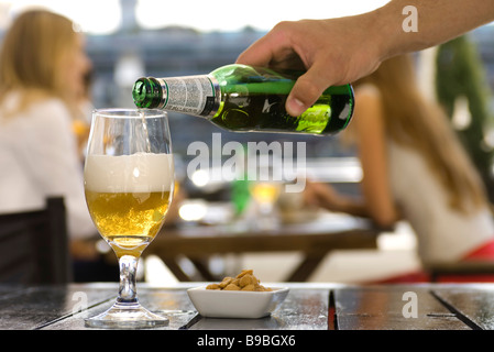 Bier in Glas im Straßencafé gießen Stockfoto