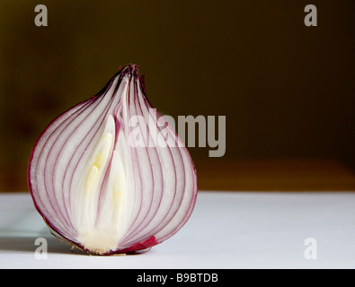 Abschnitt einer einzigen rote Zwiebel in Scheiben geschnitten, in der Mitte, vor einem dunklen Hintergrund Stockfoto