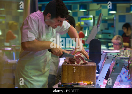 Metzger bei der Arbeit schneiden Fleisch im Alter von trocken-kuriert gewürzte italienische Schinken geheilt trocken Crudo Antipasti Schweinefleisch auf den Knochen Parma Stockfoto