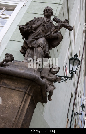 Steinstatue des Heiligen mit Kreuz am Haus Winkel in Mala Strana, Prag, Tschechische Republik. Stockfoto