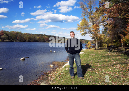 Lächelnder Mann malerischen See im Herbst stehen Stockfoto