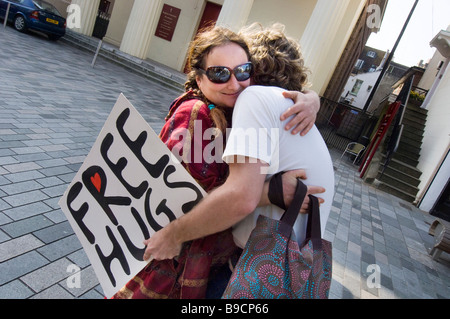 Ein junges Paar geben sich gegenseitig eine spontane Umarmung in zentralen Brighton East Sussex Stockfoto