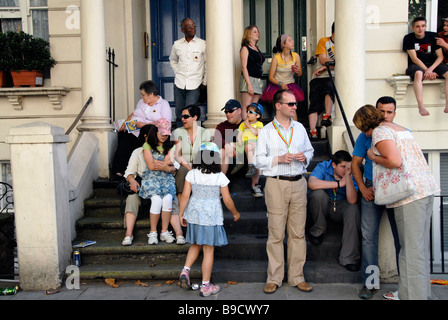 Familie und Freunde sitzen vor Haustür in West London Notting Hill Karneval Zeitpunkt Stockfoto