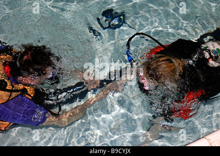 Junge Frau lernen Sie Tauchen im Pool mit Lehrer im Unterricht Tarierung unter Wasser