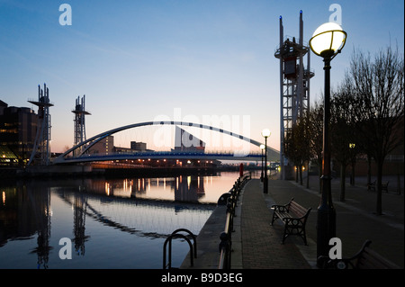 Die Millennium-Brücke bei Sonnenuntergang mit Imperial War Museum North hinter Salford Quays, Greater Manchester, England Stockfoto