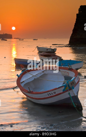 Kleine Fischerboote verankert am Playa De La Caleta bei Sonnenuntergang in der Stadt Cadiz, Provinz Cádiz, Costa De La Luz, Andalusien. Stockfoto