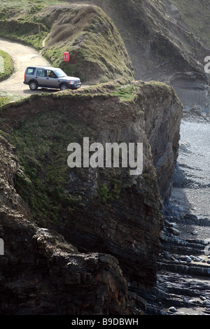 Ein Land Rover Discovery parkten auf einer Klippe mit Strand und das Meer Stockfoto