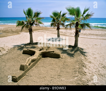 Kruzifix, Sand Kunst am Strand von Calp, Calpe, palm Trees, Costa Blanca, Provinz Alicante, Spanien Stockfoto