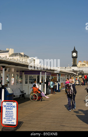 Blick entlang Palace Pier Brighton East Sussex England an einem Frühlingstag mit Menschen Touristen Stockfoto