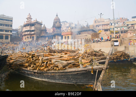 Brennholz auf den Booten mit Verbrennung der Leichen an einem Ghat Manikarnika Ghat, Fluss Ganges, Varanasi, Uttar Pradesh, Indien Stockfoto