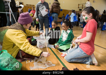 Frau, die Kinder zu lehren, wie man häkeln recyclebarer Kunststoff mit einem Green Fair in Syracuse, New York Stockfoto