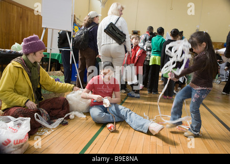 Frau, die Kinder zu lehren, wie man häkeln recyclebarer Kunststoff mit einem Green Fair in Syracuse, New York Stockfoto