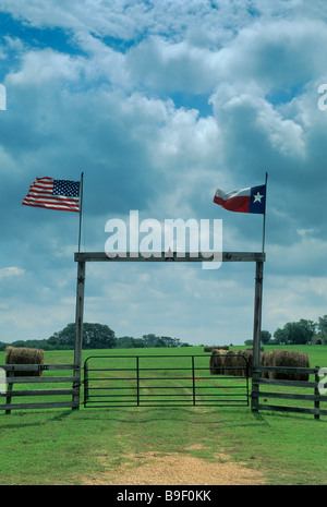 Holz-Ranch-Tor mit TX und USA Flaggen auf TX 90 Autobahn in der Nähe von Anderson in Grimes County Texas USA Stockfoto