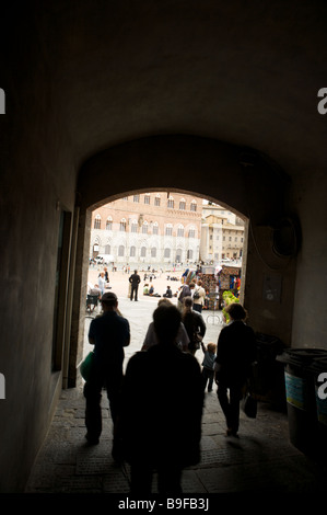 Menschen im Schatten betreten und verlassen der Piazza del Campo in Siena Italien Stockfoto