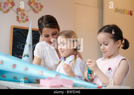 Frau, die helfen, ihren beiden Töchtern Karton Kegel dekorieren Stockfoto