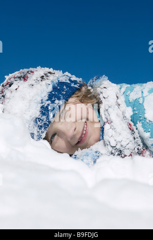 Porträt eines jungen am Schnee liegen und lächelnd Stockfoto