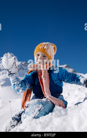 Porträt eines jungen Schneeball werfen und lächelnd auf schneebedeckter Landschaft Stockfoto