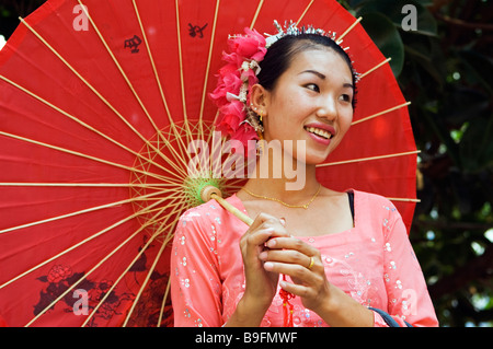 China Yunnan Provinz Xishuangbanna Jinghong Stadt A Mädchen in traditioneller Kleidung mit Sonnenschirm A Water Splashing Festival Stockfoto