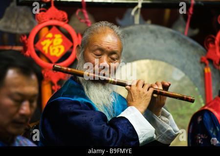 China, Yunnan Provinz, Stadt Lijiang. Naxi Orchester Musiker Playng Querflöte in die UNESCO-Weltkulturerbe Stockfoto