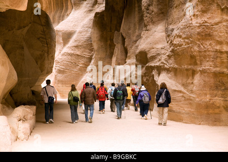 Touristen auf einer geführten Tour Fuß durch den Siq auf ihrem Weg nach Petra, Jordanien Stockfoto