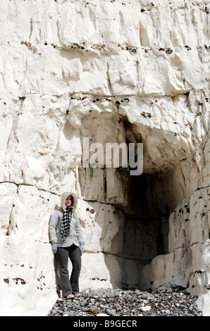 Frau im Wintermantel steht an Kreidefelsen entlang der Seven Sisters bei Birling Gap in East Sussex UK Stockfoto