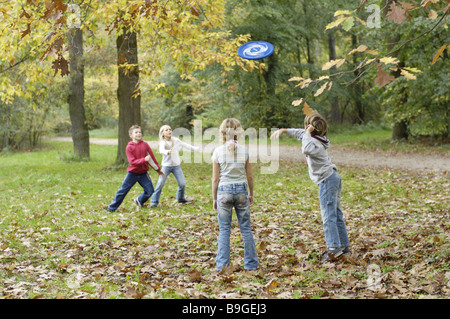 Kinder-Mädchen, die jungen fröhlich Wald Freunde 8-12 Jahre vier Gruppe Freundschaft spielen Frisbee fun-Spiel, die Frisbee Fänge Weg wirft Stockfoto