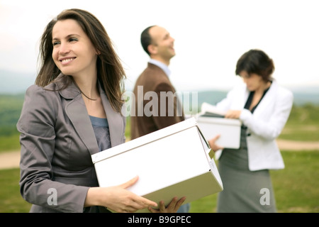 glücklich lächelnd Business-Team im Freien organisieren Dateien und Boxen auf einem Hügel Stockfoto