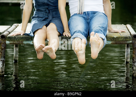 Seebrücke paar Detail Beinen sitzen Stockfoto