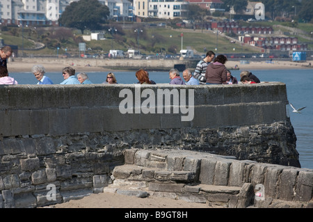 Sitzen auf dem Deich am Meer Stockfoto