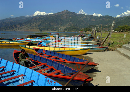 Ein nepalesischer Mann sitzt in seinem Boot am Phewa-See in Pokhara, Nepal. Stockfoto