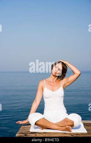 Frau beim Yoga auf einer Mole Stockfoto