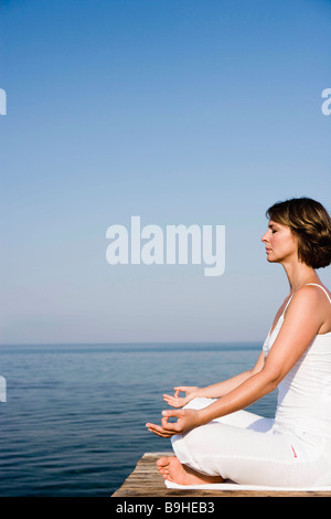 Frau beim Yoga auf einer Mole Stockfoto