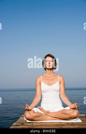 Frau beim Yoga auf einer Mole Stockfoto