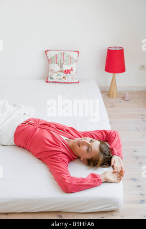 Frau auf einem Bett liegend Stockfoto