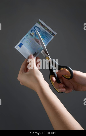 Weibliche Hände schneiden ein-Euro-Schein Stockfoto