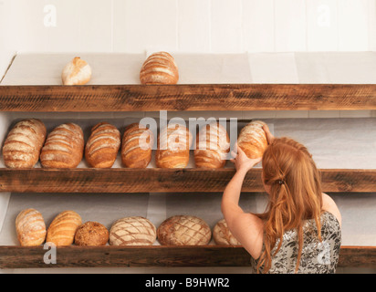 Frau, die Regale in Bäckerei Stockfoto