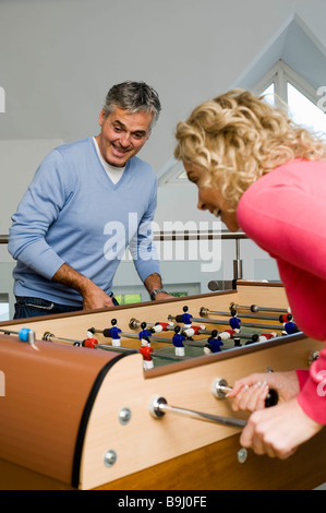 Paare, die Spaß spielen Tischfußball Stockfoto