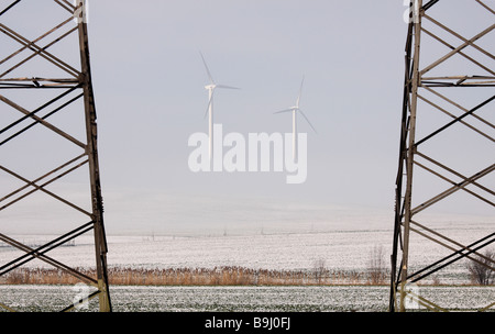 Strommasten und Windkraftanlagen im Nebel Stockfoto