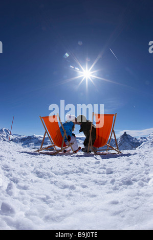 Paar küssen/liegen in Liegestühlen Stockfoto