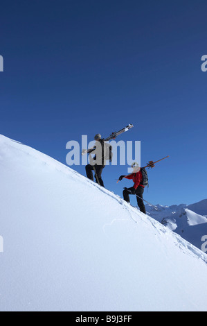 Skifahrer, die zu Fuß auf der Seite des Berges Stockfoto